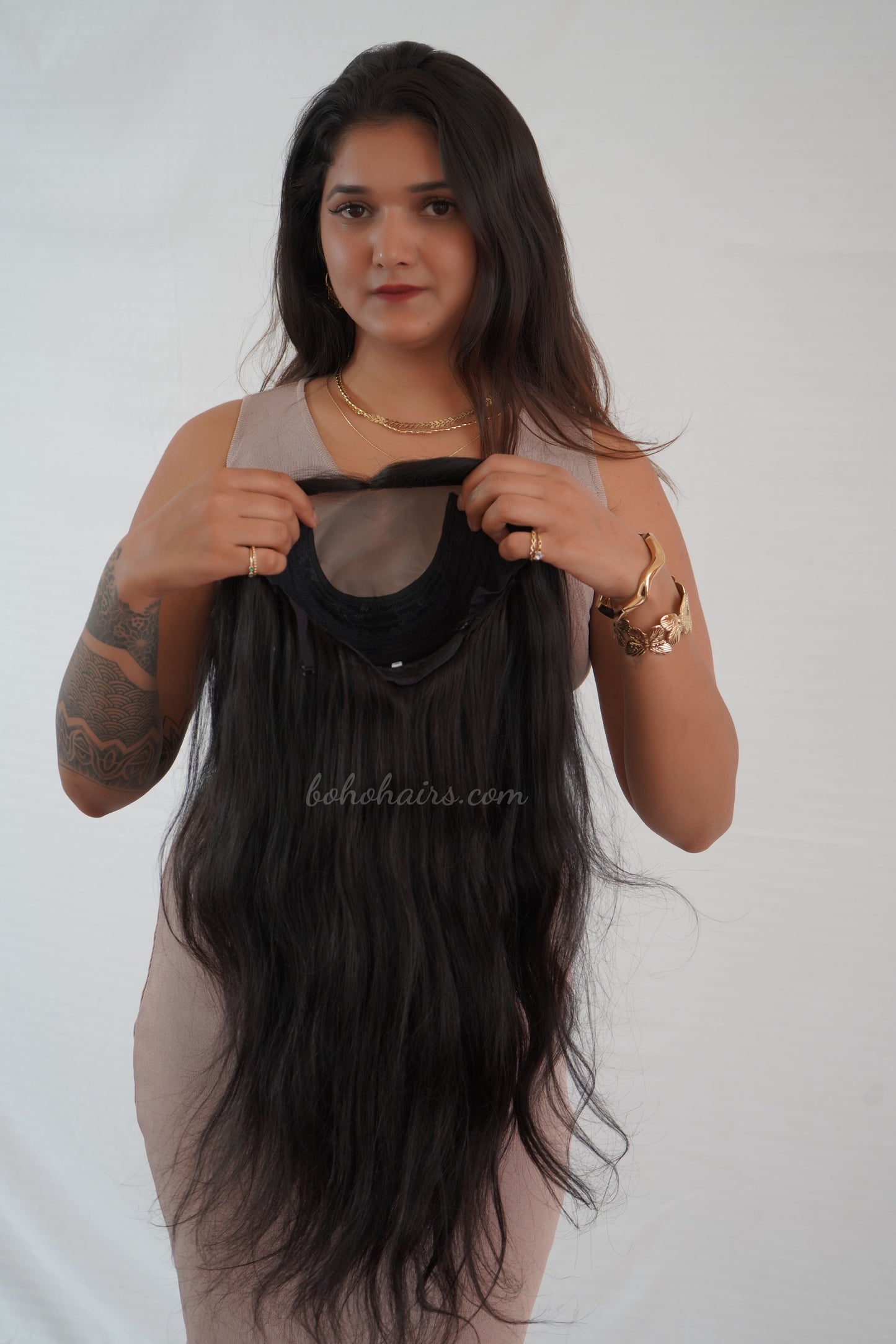 Woman holding a black hair extension against a white background