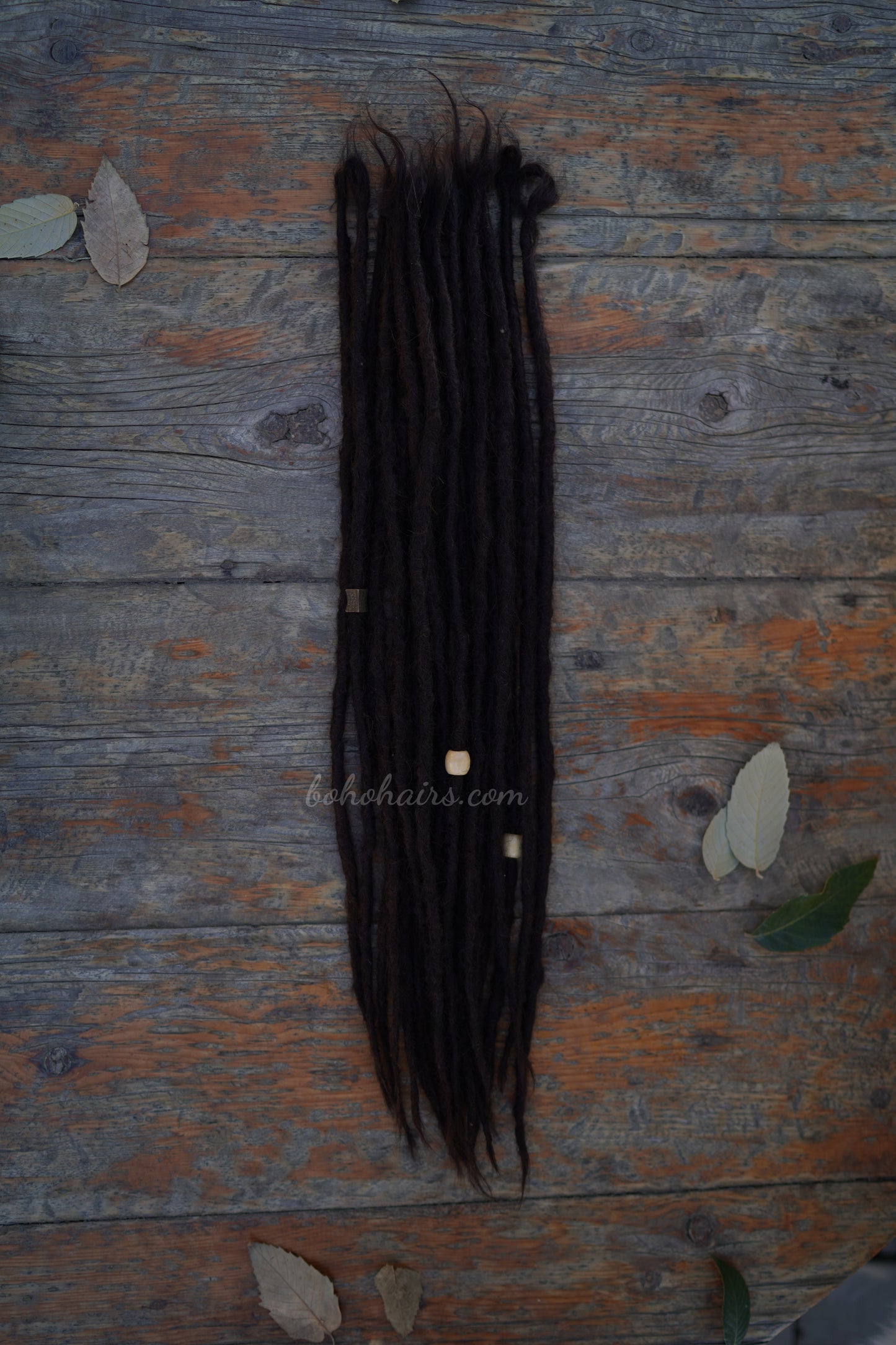Bundle of black hair extensions on a wooden surface